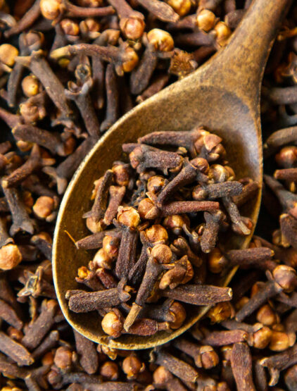 top view dried cloves with a wooden spoon